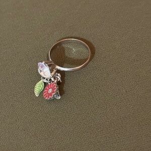 charm ring featuring a dangling flower and leaf